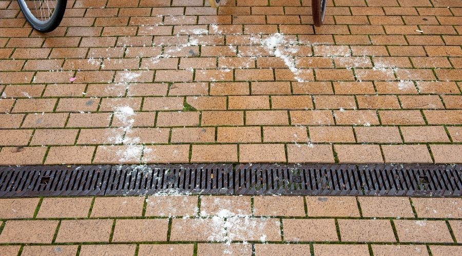 Winter salt stains on a brick paver surface.