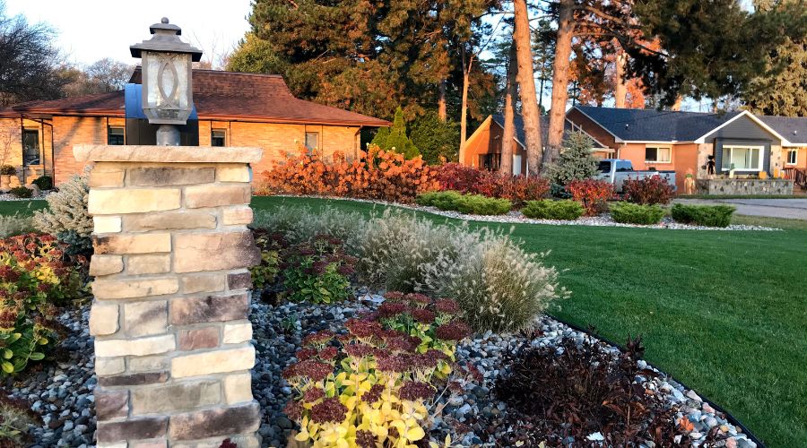 A Michigan property designed by Bay Landscaping with fall plants and a green lawn.